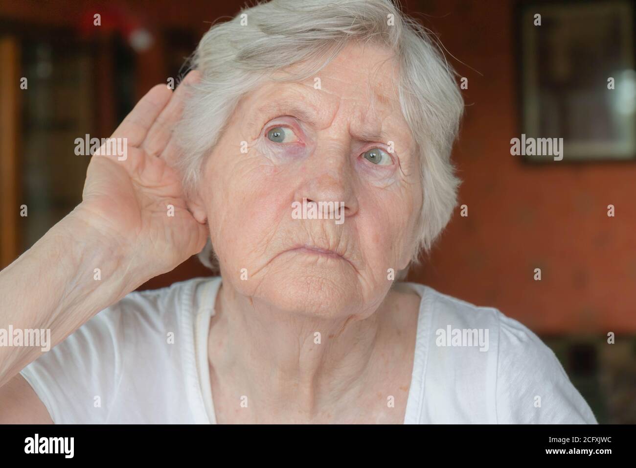 Femme âgée tenant la main à l'oreille. Vieille dame ayant des problèmes d'audition. Portrait de la grand-mère essayant d'entendre quelque chose. Problèmes d'audition, les aînés hea Banque D'Images