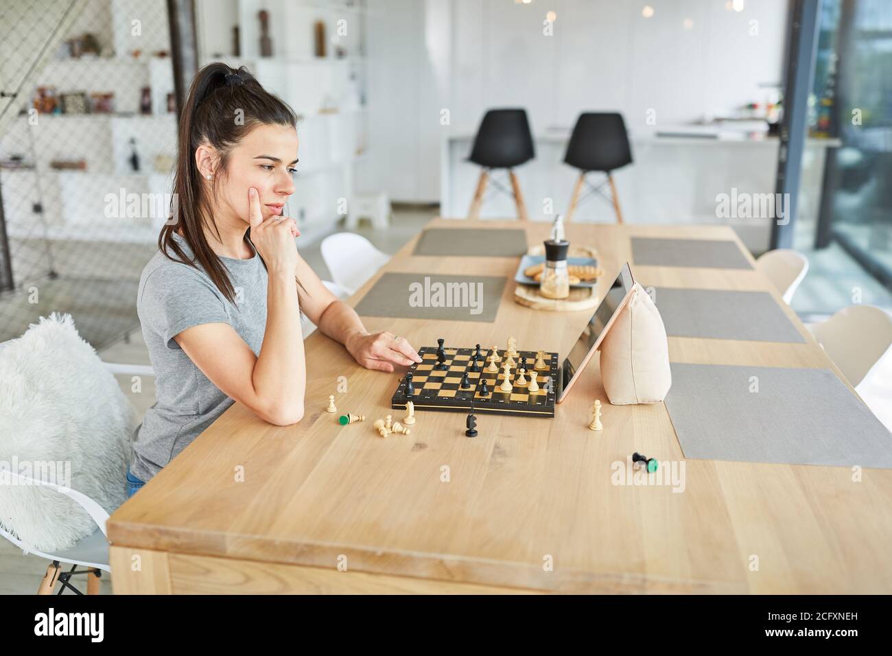 Femme à la maison jouant aux échecs dans le chat vidéo virtuel en ligne Banque D'Images
