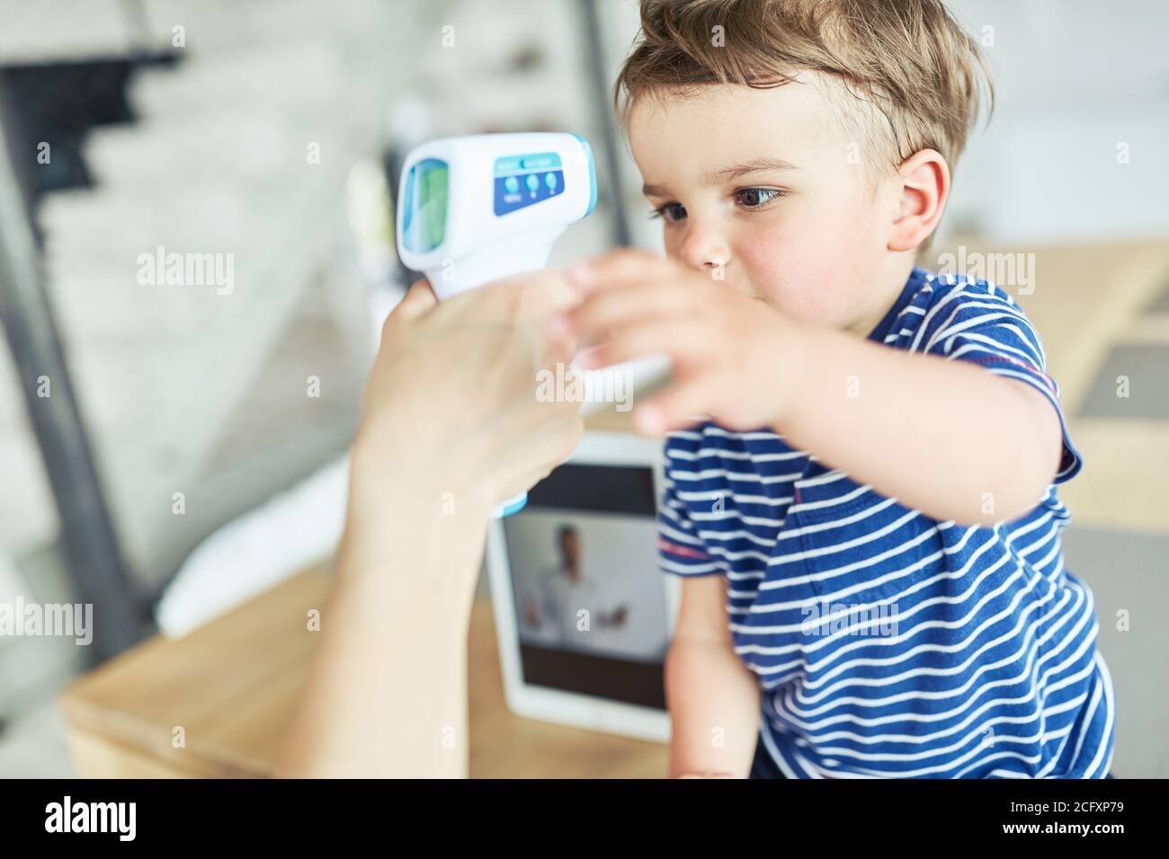 Enfant mesurant une fièvre en médecine consultation en ligne par vidéo clavarder Banque D'Images