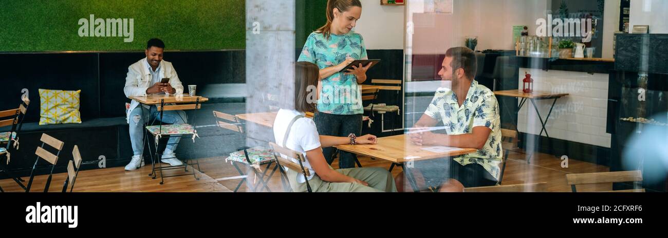 Serveuse prenant la commande du client avec une tablette Banque D'Images