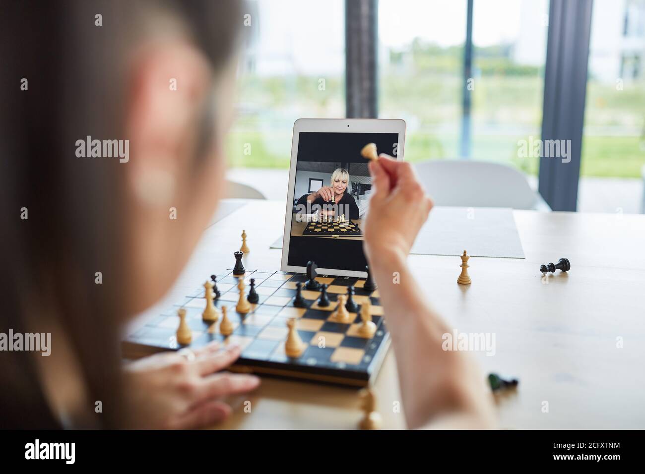 Deux femmes jouent aux échecs dans le chat vidéo en ligne comme un passe-temps ou en compétition Banque D'Images