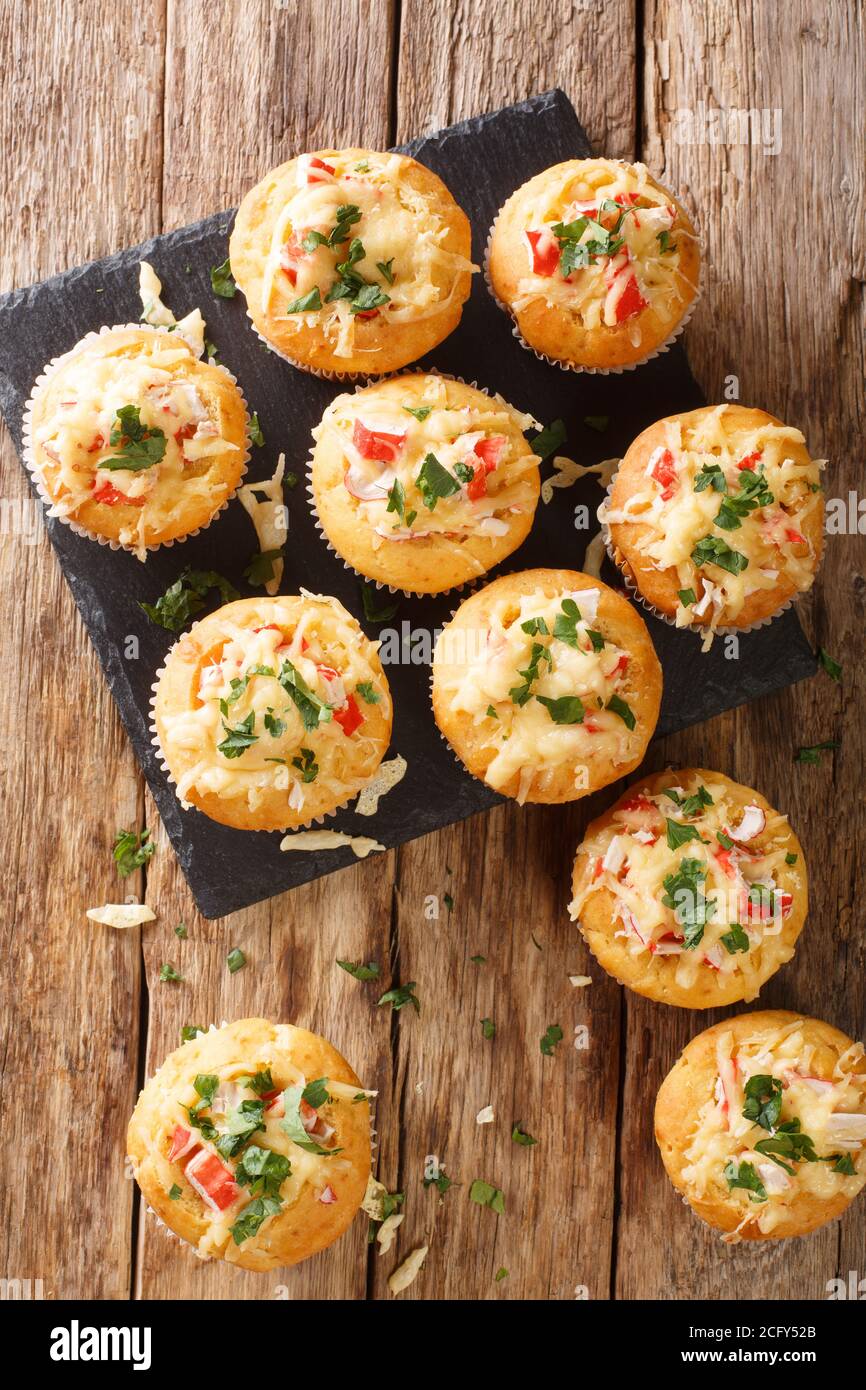 Des muffins au maïs avec de la viande de crabe et du fromage en gros plan sur un tableau d'ardoise sur la table. Vue verticale du dessus Banque D'Images