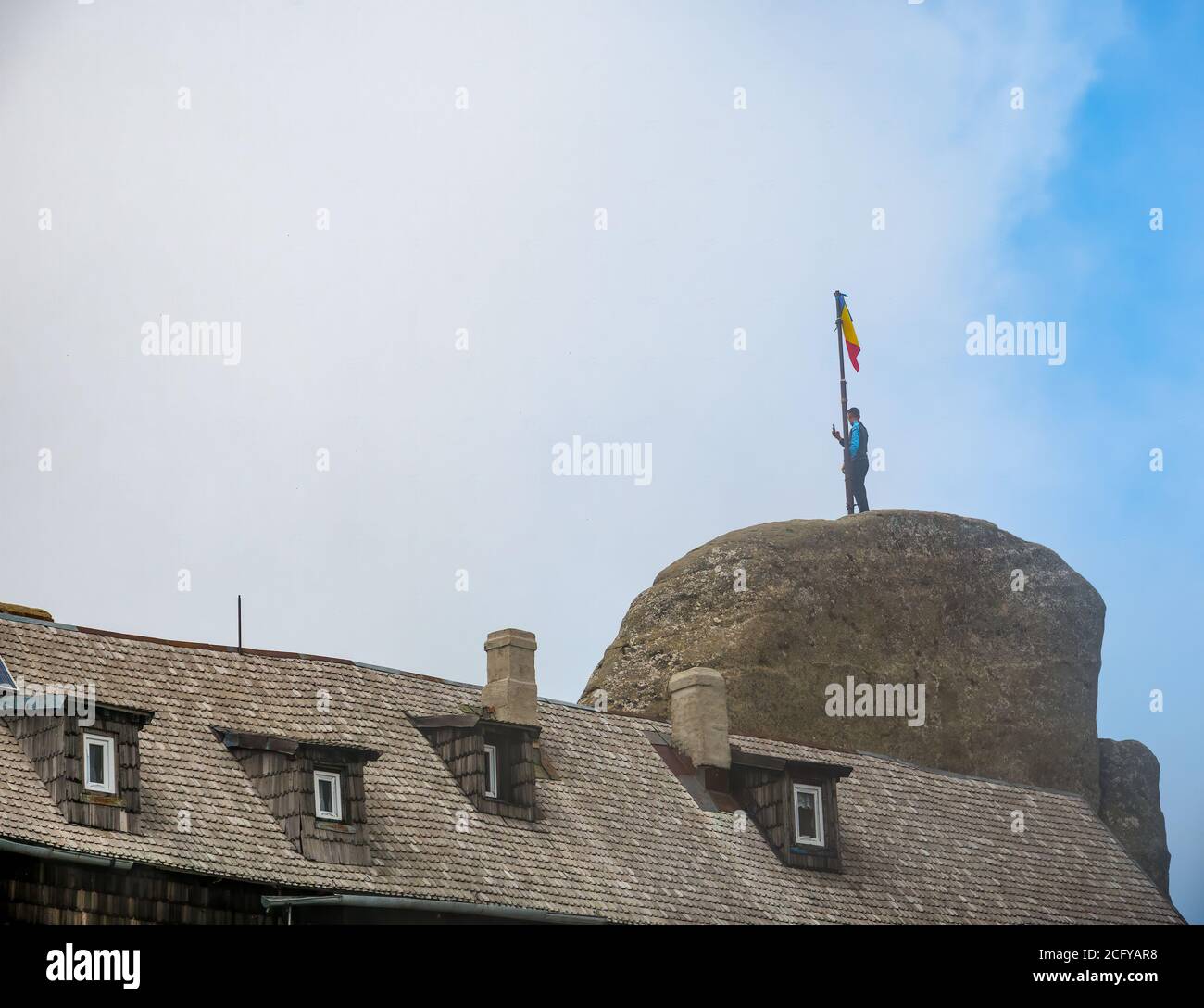 Homme debout sur le grand rocher depuis le sommet de l'OMU et prise de photos Banque D'Images