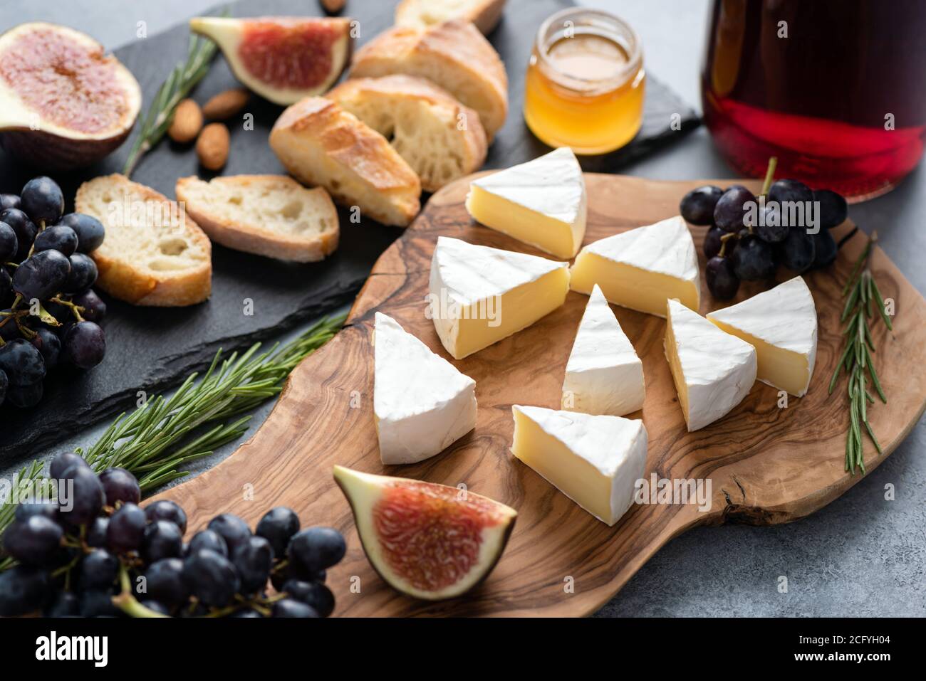 Fromage camambert aux figues, raisins, miel et vin. Cuisine gastronomique, assiette de fromages pour hors-d'œuvre Banque D'Images