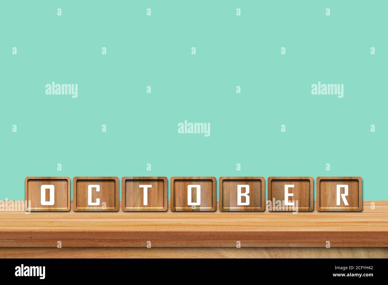 Blocs de l'alphabet d'octobre sur une table en bois avec fond bleu. Copier l'espace pour le texte Banque D'Images