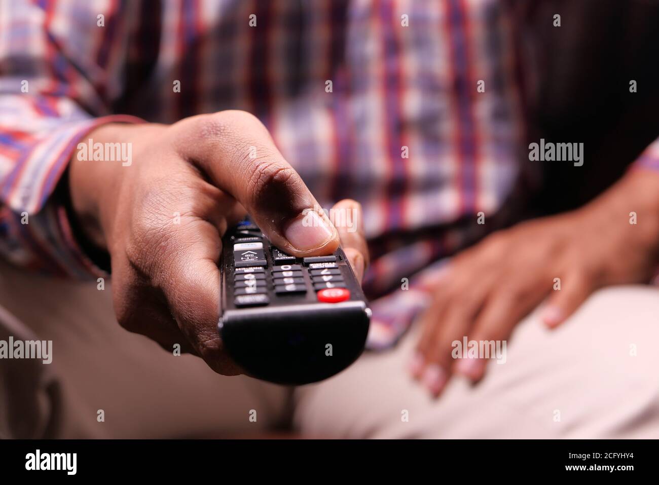 gros plan sur un homme tenant la télécommande du téléviseur. Banque D'Images