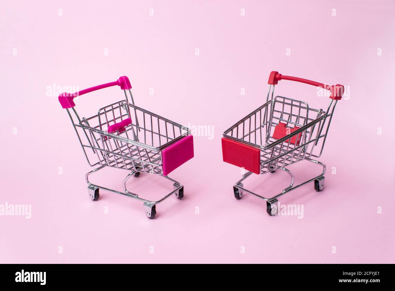 Shopping, achats, supermarché, vente, concept de centre commercial. Deux petits chariots à provisions en métal vides sur fond léger. Mise au point sélective Banque D'Images