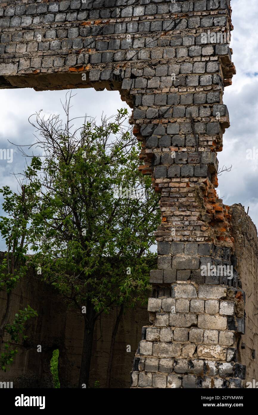 Mur détruit. Fragments de la paroi contre le ciel. Ruines de maisons. Jour d'été Banque D'Images
