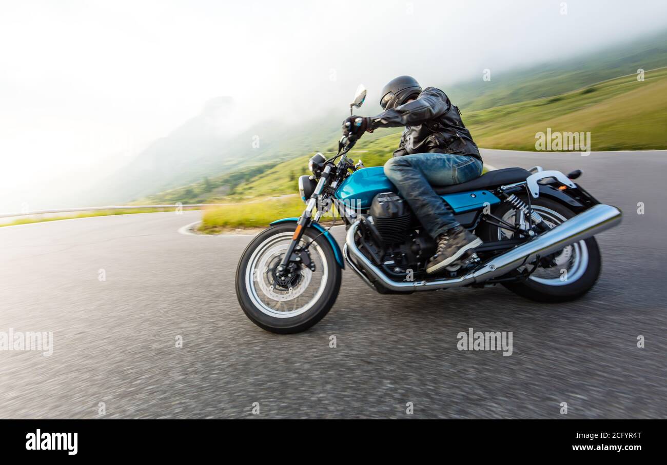 Conducteur de moto dans le paysage alpin. Photo de style de vie avec effet de flou de mouvement et recopie. Banque D'Images