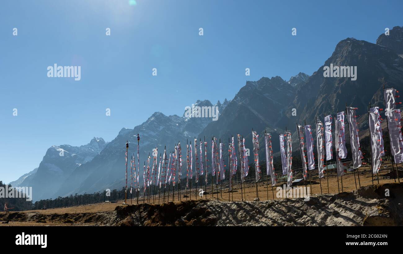 Drapeaux de prière tibétains soufflant avec le vent de haute montagne se situe à l'arrière-plan et le soleil se trouve à l'arrière-plan du vallée de fleurs à Sikkim Inde Banque D'Images