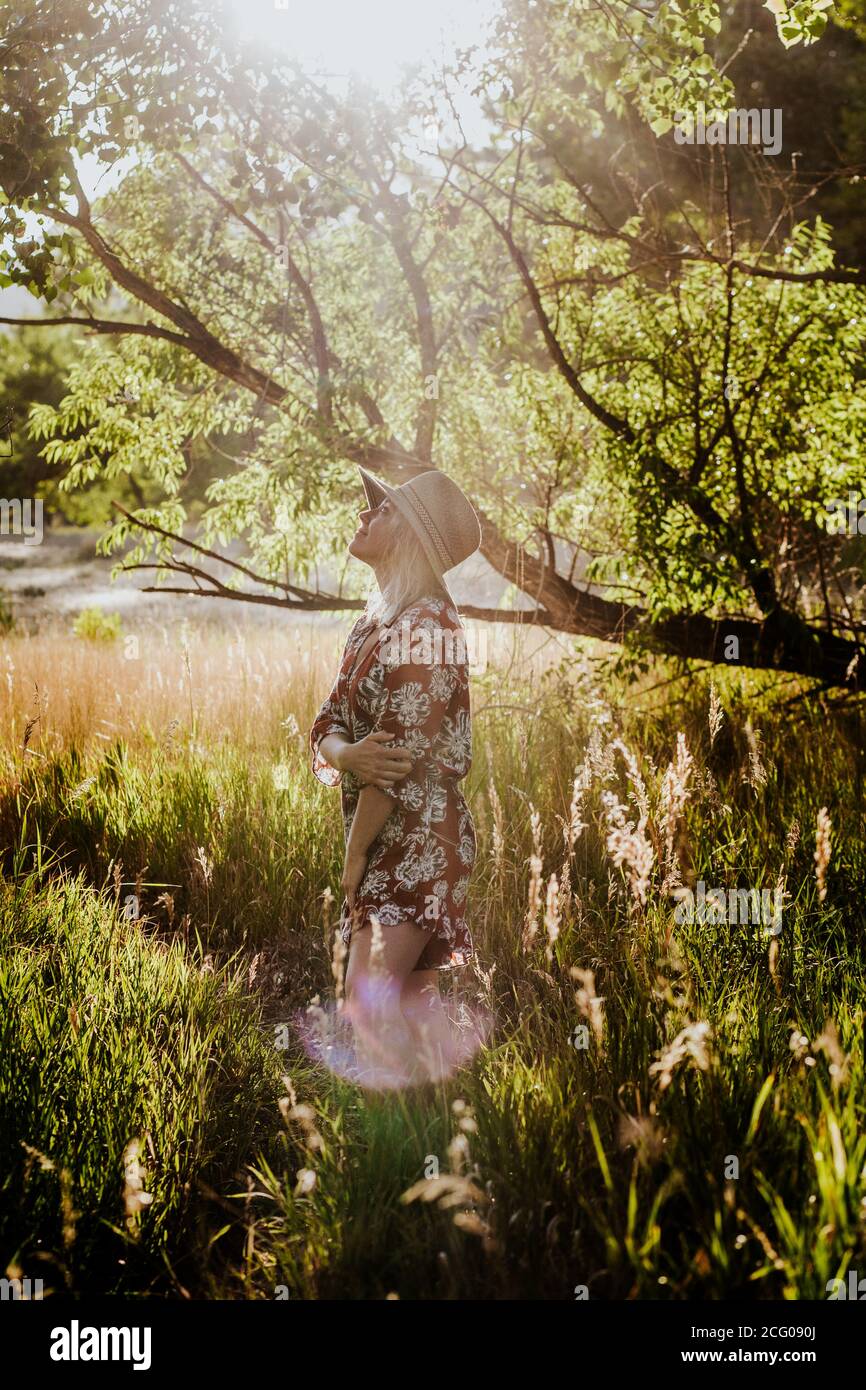 Portrait vertical d'une jeune femme debout en forêt loin Banque D'Images