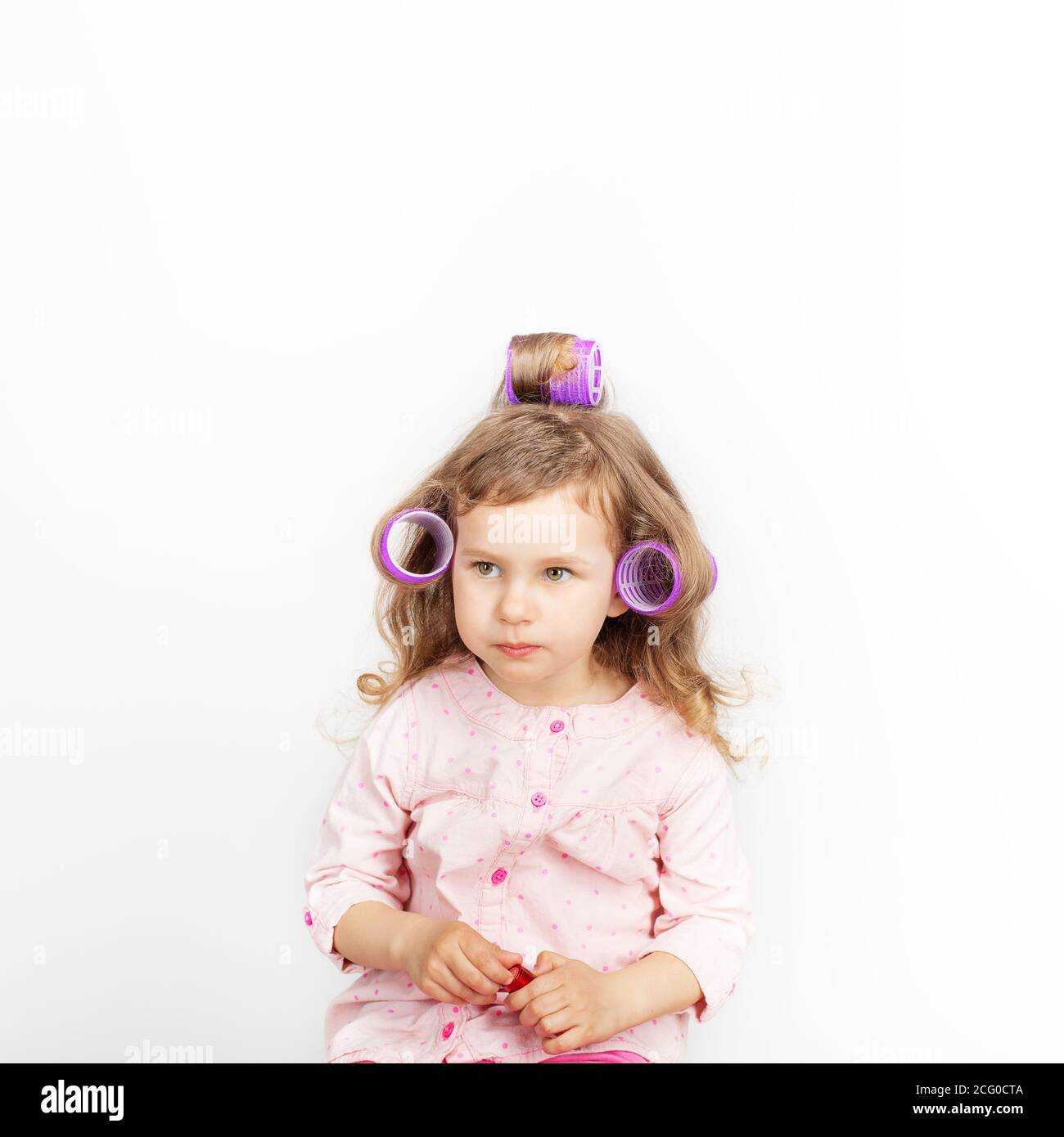 Belle Petite Fille Avec Des Boucles Sur Sa Tete Regardant L Appareil Photo Et S Amuser A La Maison Jour De Conge Vacances Jour De Repos Gratuit Hors Temps Mode Bebe G Photo Stock