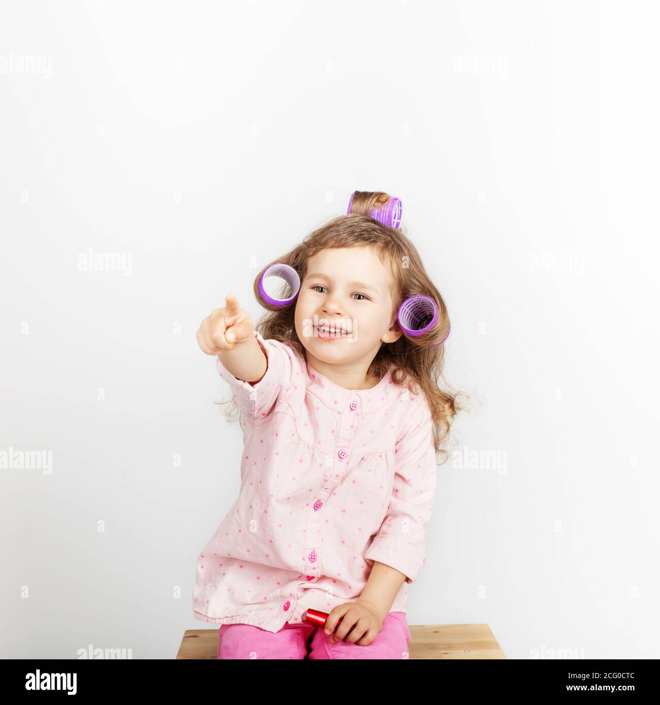 Belle Petite Fille Avec Des Boucles Sur Sa Tete Regardant L Appareil Photo Et S Amuser A La Maison Jour De Conge Vacances Jour De Repos Gratuit Hors Temps Mode Bebe G Photo Stock