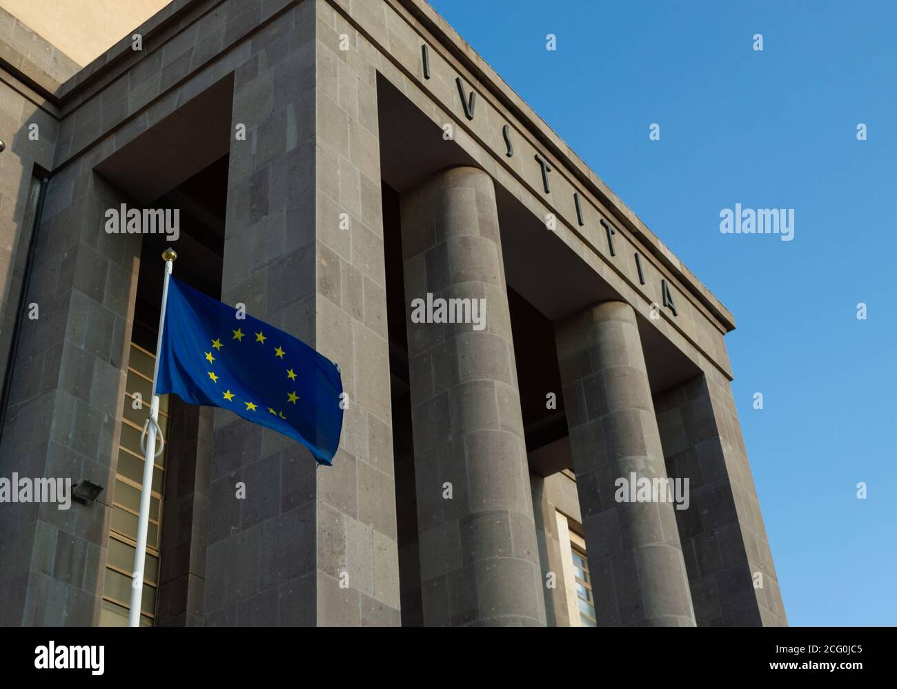 Cagliari, Sardaigne, Italie - septembre 06 2020: Drapeau européen en dehors d'un tribunal avec le mot latin IUSTITIA ( Justice), drapeau européen à vent en dehors de b Banque D'Images