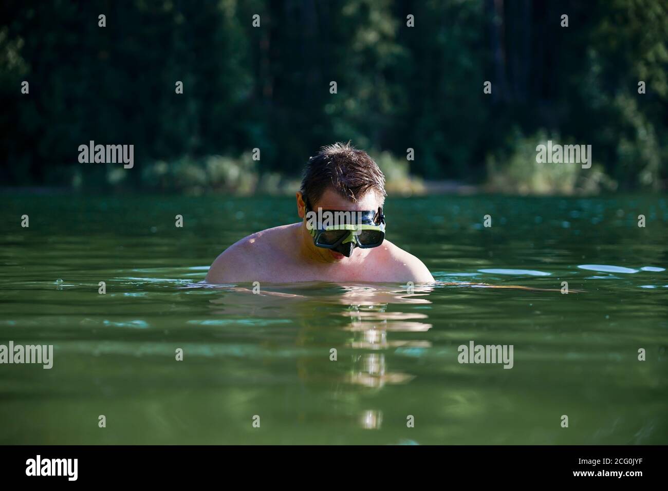 Un gars dans un masque de plongée plonge hors de l'eau Banque D'Images