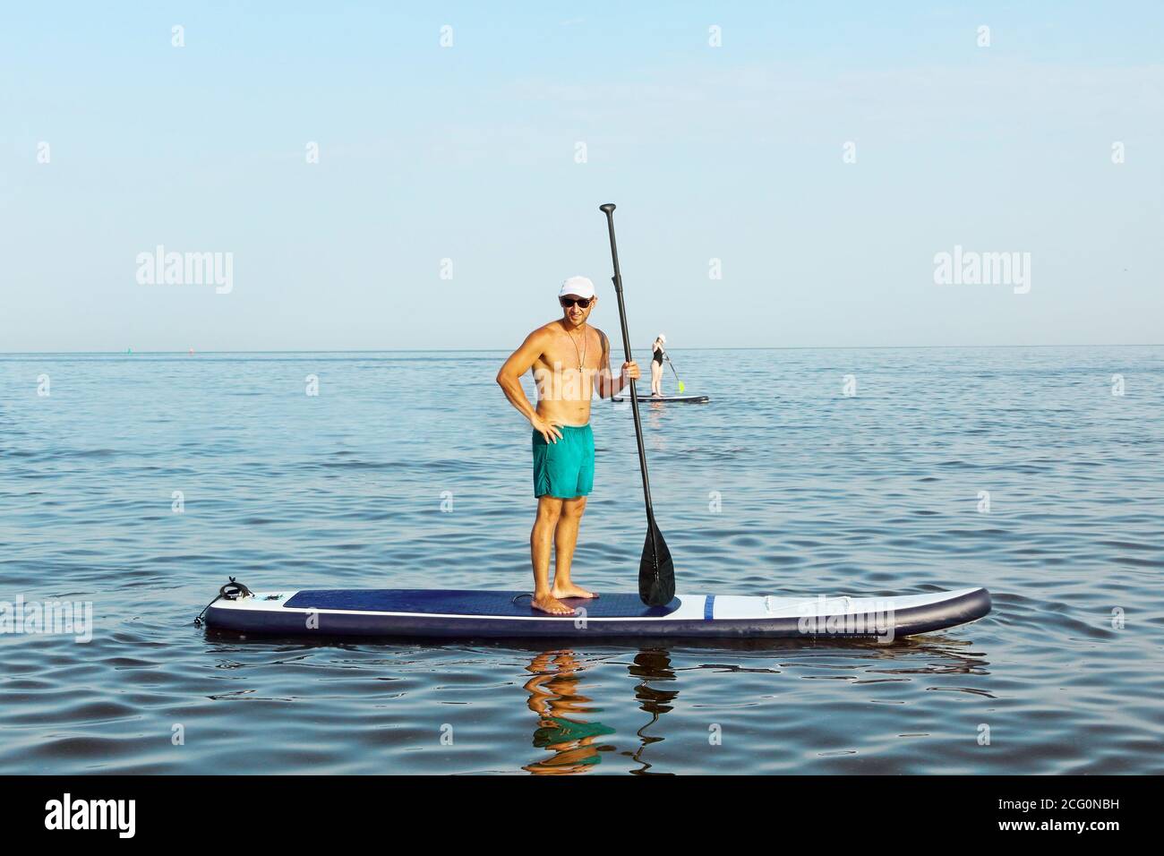 Navigation SAP. L'homme s'entraîne sur un panneau SUP dans la mer bleue. Banque D'Images