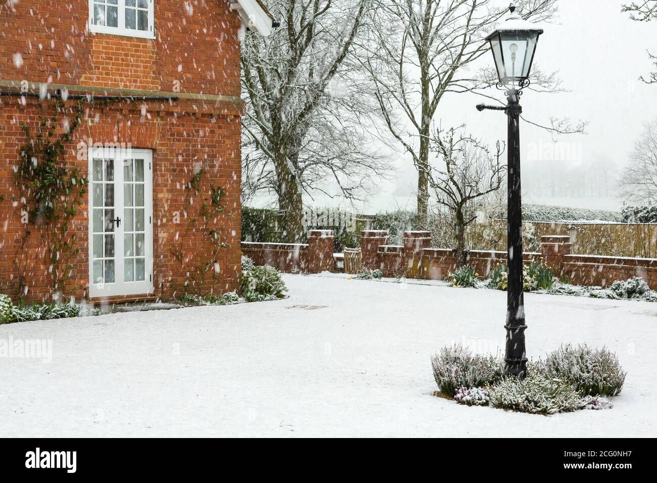 Jardin anglais d'une maison de campagne dans la neige d'hiver, Royaume-Uni Banque D'Images