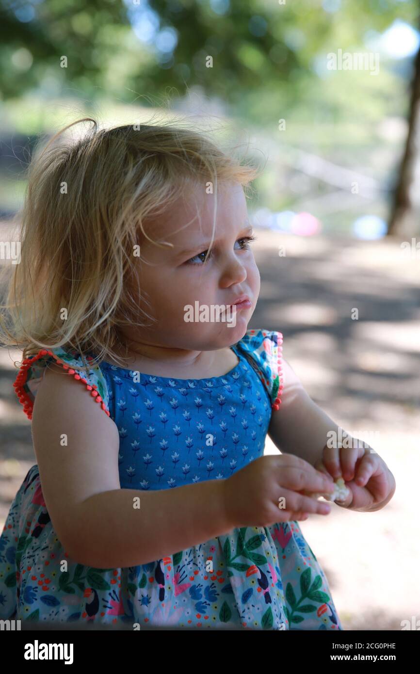 petite fille de 2 ans dans une sundress qui a l'air triste Banque D'Images
