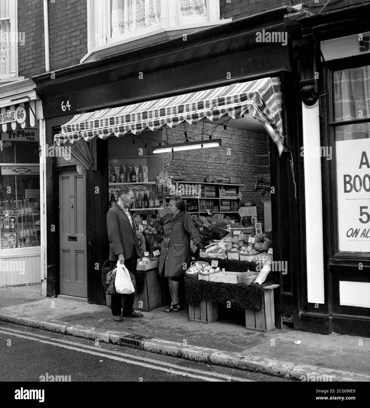 AJAXNETPHOTO. 1975. SOUTHSEA, ANGLETERRE. - TEMPS POUR UNE DISCUSSION - ROUTE DU CHÂTEAU FRAIS MAGASIN DE LÉGUMES PROPRIÉTAIRE ET CLIENT. PHOTO:JONATHAN EASTLAND/AJAX REF:750081 087 Banque D'Images