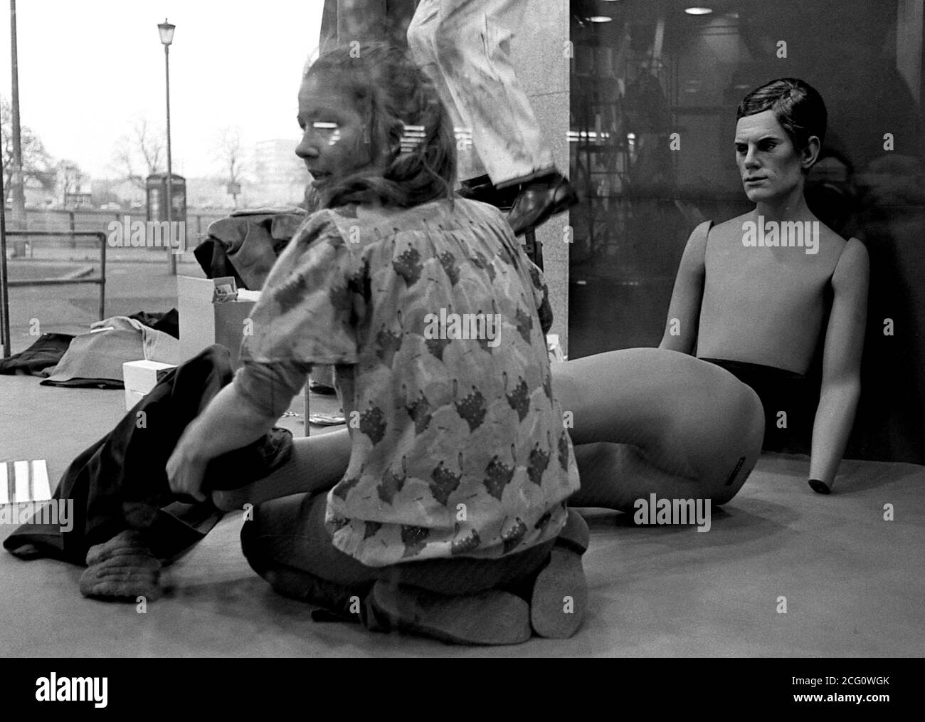 AJAXNETPHOTO. 1975. SOUTHSEA, ANGLETERRE. - TRAVAIL DE MODÉLISATION - MAGASIN DE DÉPARTEMENT ASSISTANTS ROBES MANNEQUIN PRÊT POUR FENÊTRE DISPLAY.PHOTO:JONATHAN EASTLAND/AJAX REF:750110 8A 17 Banque D'Images