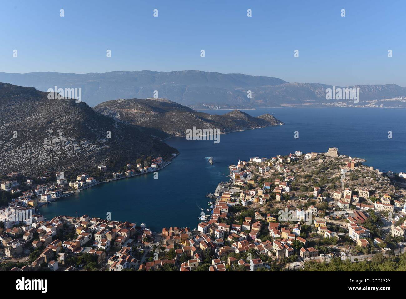 *** STRICTEMENT PAS DE VENTES AUX MÉDIAS OU ÉDITEURS FRANÇAIS - DROITS RÉSERVÉS ***08 septembre 2020 - Kastellorizo, Grèce: Vue d'ensemble sur le port de l'île de Kastellorizo, avec la côte de la Turquie très visible en arrière-plan. Un navire de guerre grec est visible au milieu du port, alors qu'il se prépare à partir pour une patrouille. Les tensions entre la Grèce et la Turquie se sont intensifiés sur cette île de 12 kilomètres carrés, qui se trouve au large de la côte turque et est l'avant-poste grec le plus éloigné de la Méditerranée orientale. La petite île est essentielle aux demandes d'énergie des deux pays dans la Méditerranée orientale. Banque D'Images