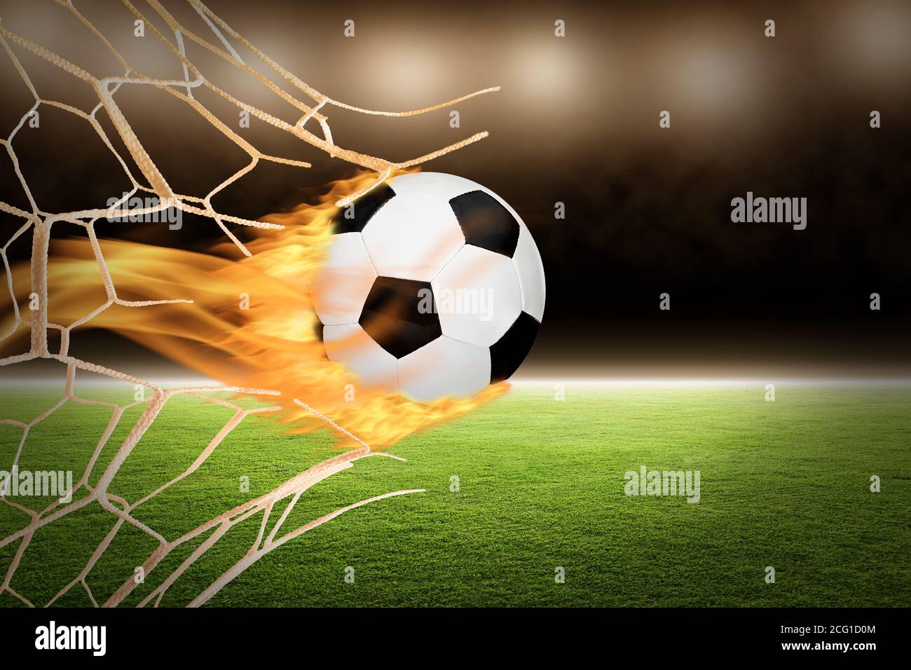 Ballon de football flamboyant avec flammes à travers un filet de but cassé avec espace de copie. Banque D'Images