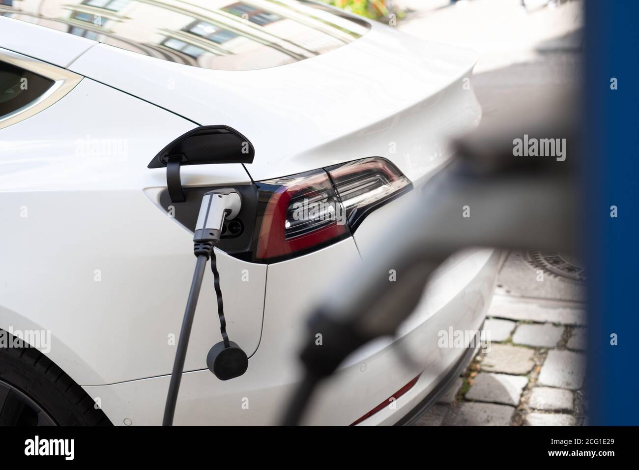 Alimentation électrique pour le chargement de la voiture électrique. Station de charge de voiture électrique. Gros plan de l'alimentation branchée sur une voiture électrique en cours de charge Banque D'Images