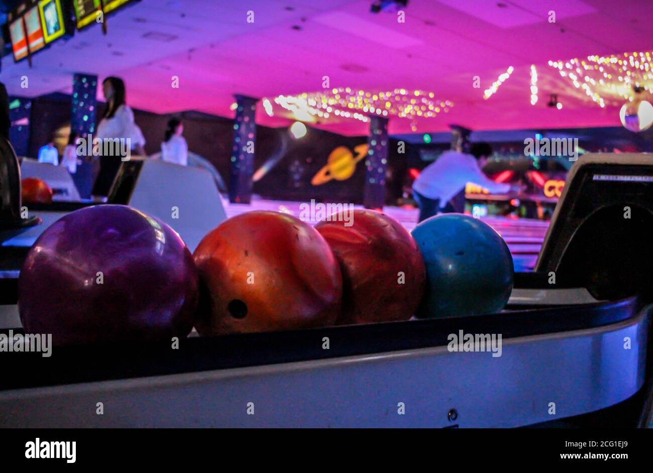 Boules de bowling à l'intérieur d'une piste de bowling sombre et éclairée au néon Banque D'Images