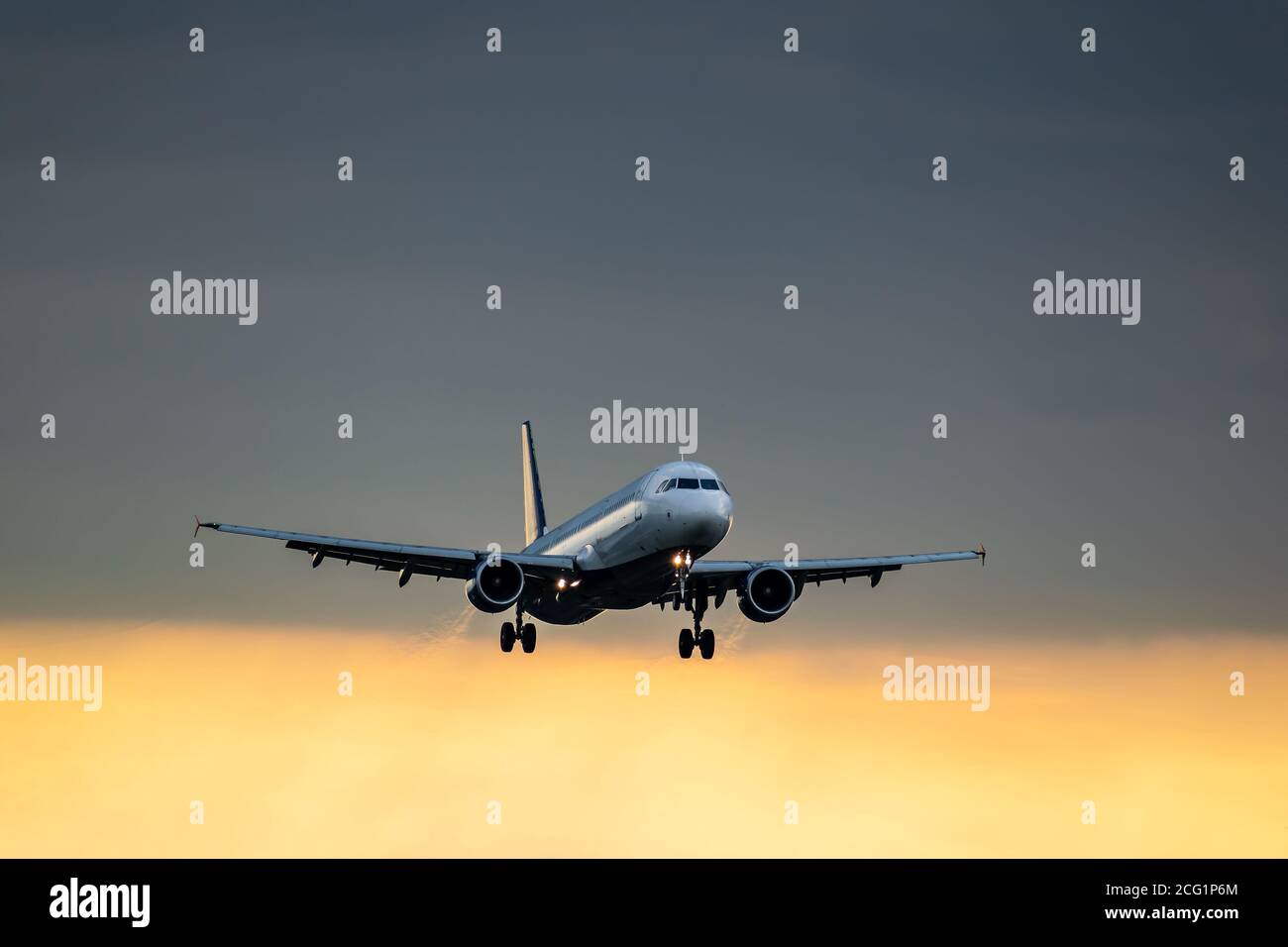 L'avion passager atterrit au coucher du soleil après la tempête Banque D'Images