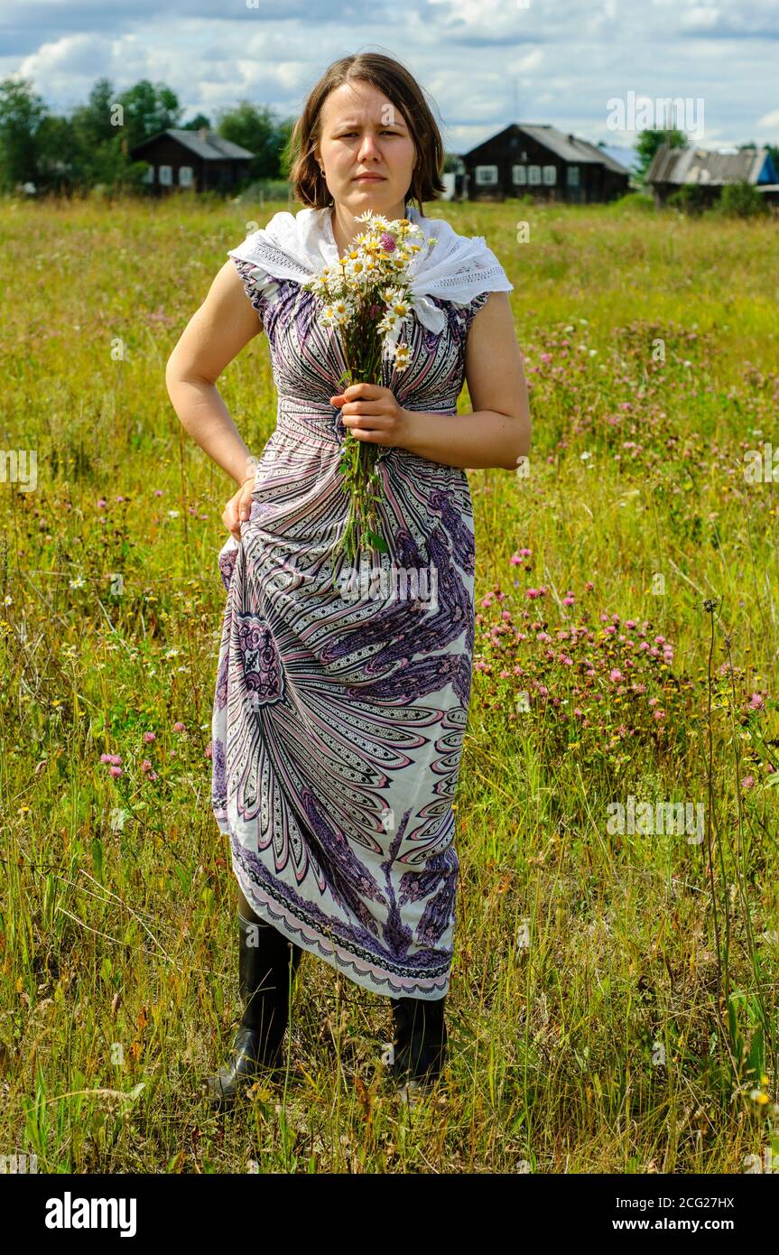 Jeune femme en vêtements vintage avec bouquet de fleurs sauvages dans le  pays. Cottagecore Photo Stock - Alamy