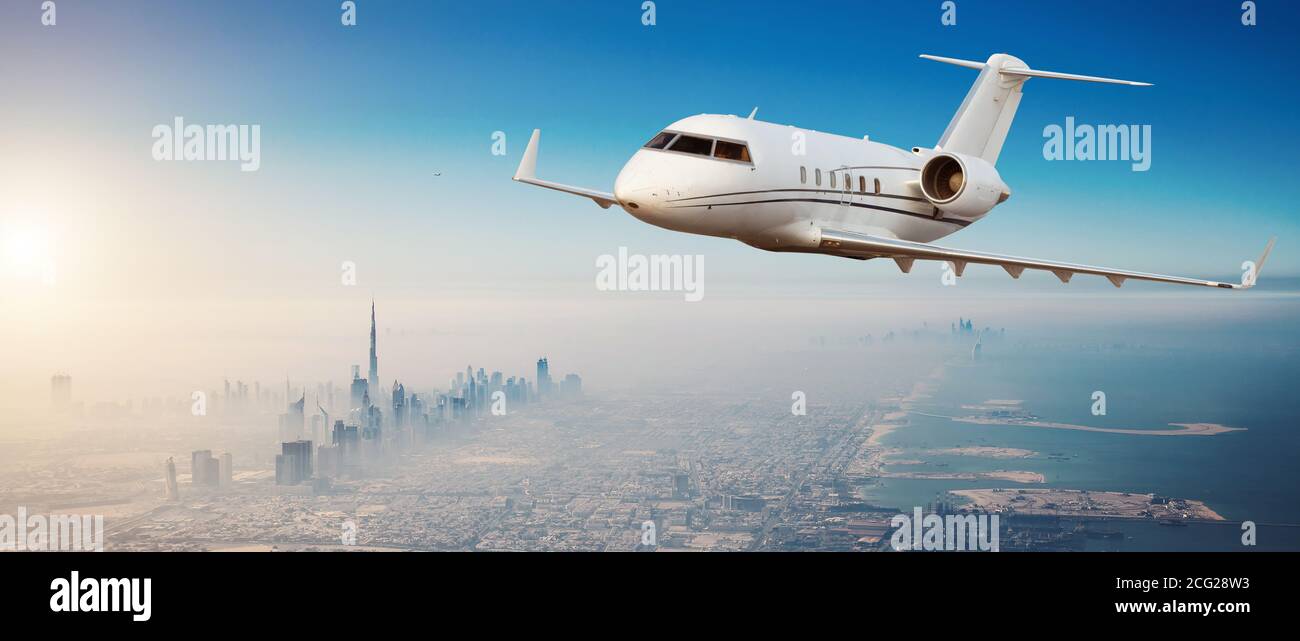 Jet Privé avion volant au-dessus de la ville de Dubaï en beau coucher de la lumière. Hôtel moderne et le mode de transport le plus rapide, la vie de l'entreprise. Banque D'Images