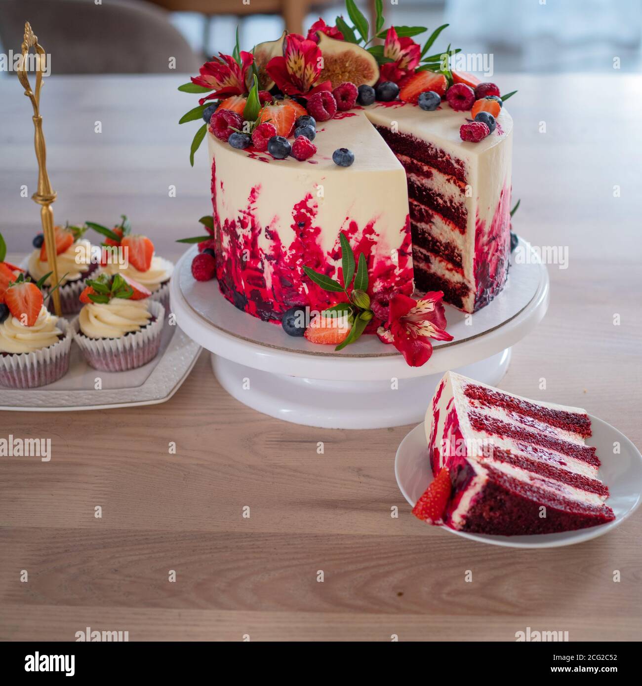 Grand beau gâteau de velours rouge, avec fleurs et baies sur le dessus.  Trancher sur une assiette, dessert. Gâteaux et muffins, friandises de  vacances Photo Stock - Alamy