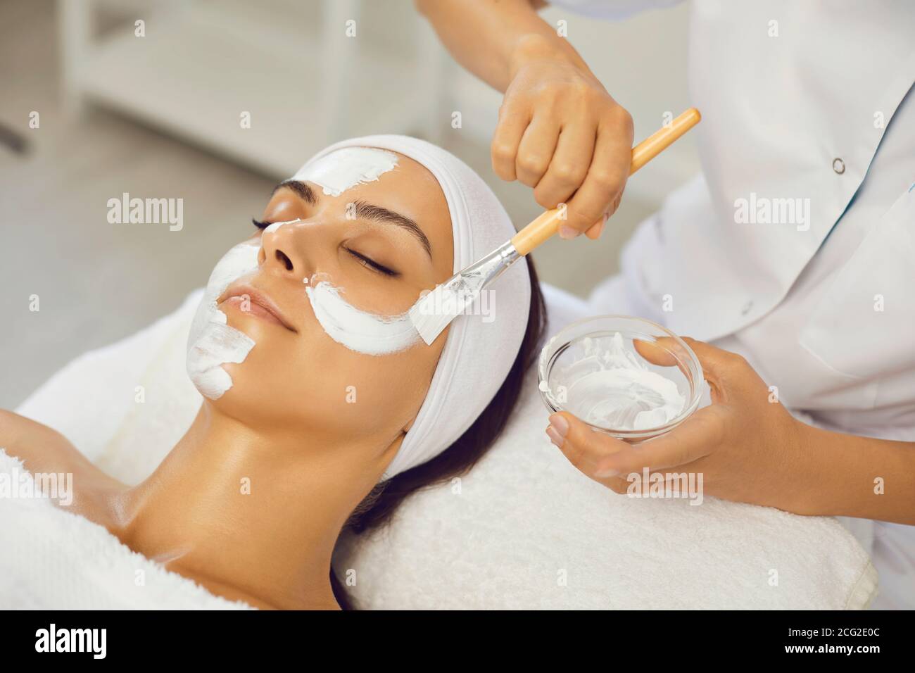 Masque d'étalement pour femme sereine au salon de beauté spa Banque D'Images