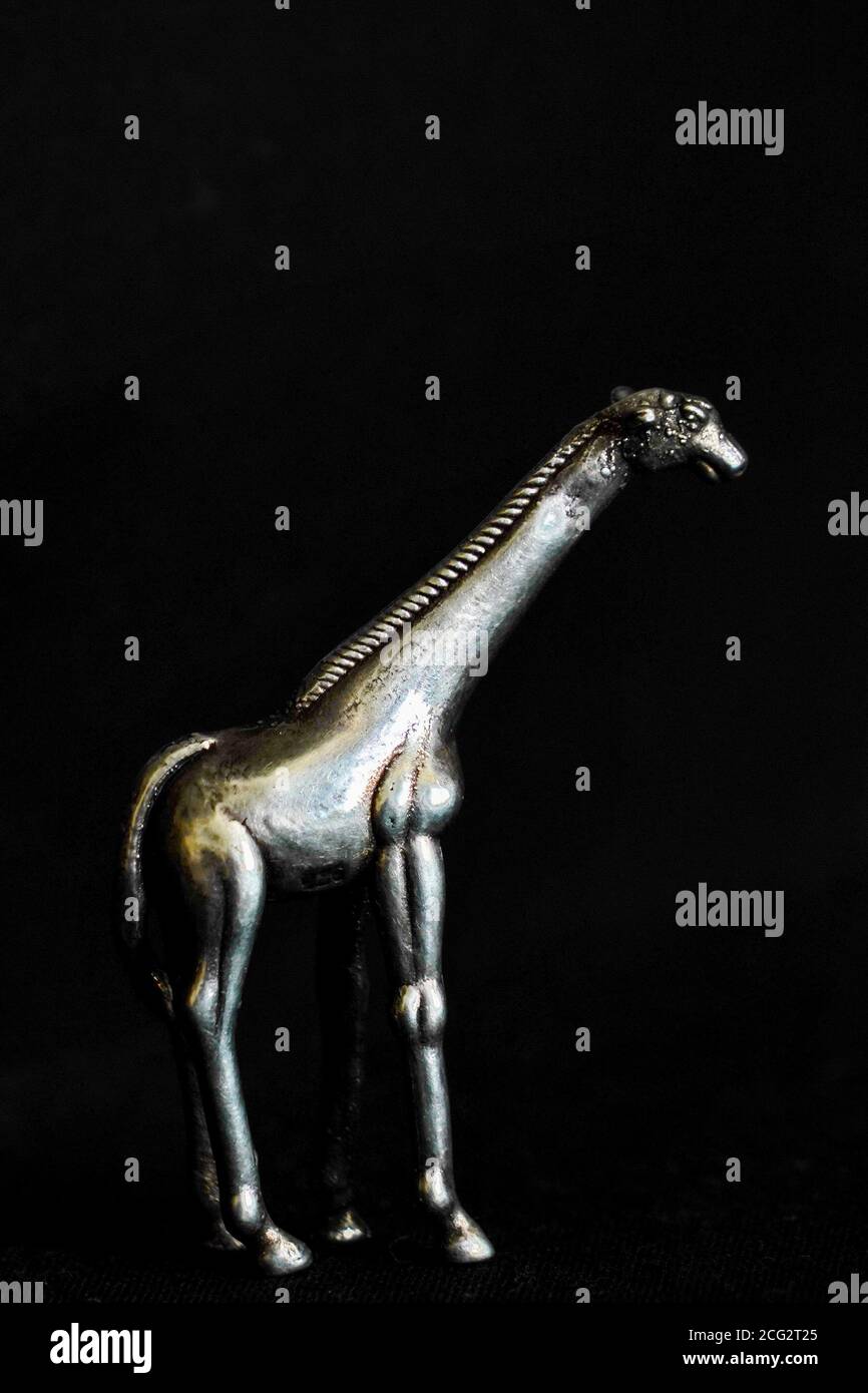 Statuette girafe sur fond noir Banque D'Images