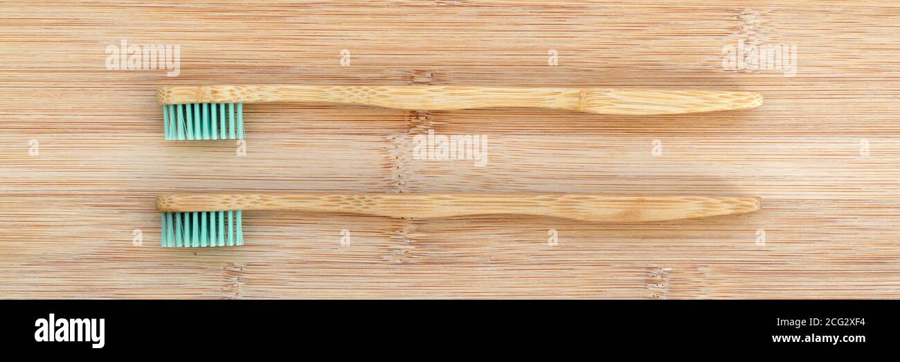Ensemble de deux brosses à dents en bambou sur fond panoramique en bois. Bannière Web de concept d'environnement sans déchets, sans plastique Banque D'Images