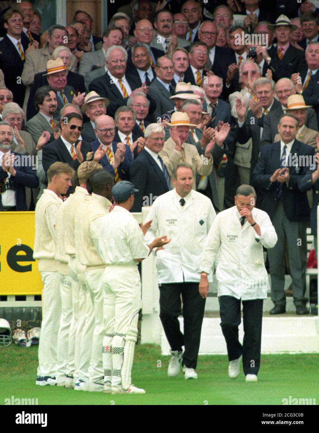 Le juge-arbitre Harold 'Dickie' Bird (à droite) élimine une larme alors qu'il est applaudi par les membres du MCC et de l'équipe d'Angleterre tout en s'éloignant avec les autres juges-arbitres australiens Darrell cheveux sur le terrain de Lord ce matin (jeudi) pour le jour d'ouverture du dernier match d'essai d'oiseau comme arbitre avant sa retraite. Voir PA Story CRICKET Bird/photo par Rebecca Naden/PA. Banque D'Images