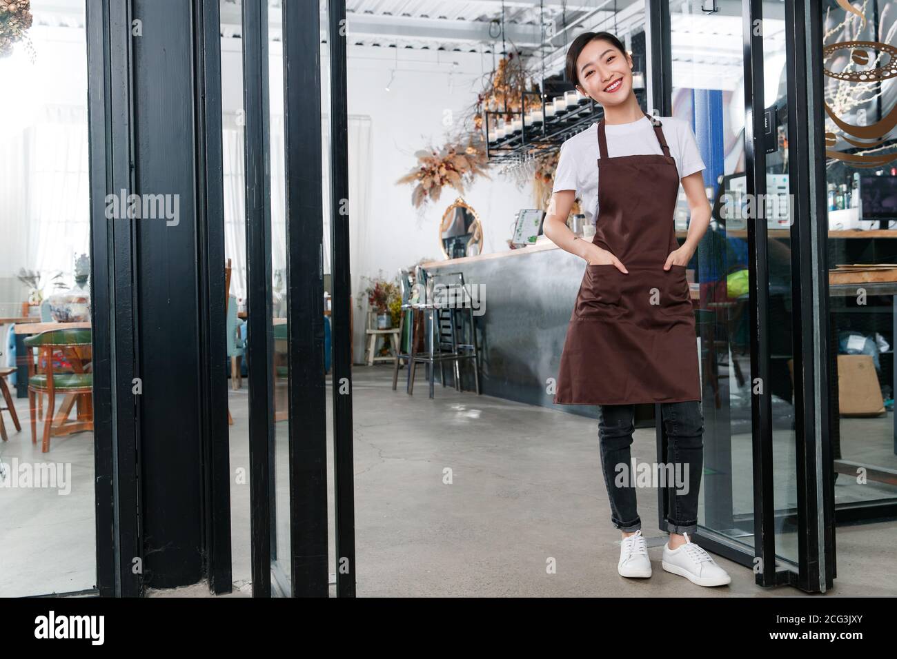 Debout à la porte de la serveuse du café Banque D'Images