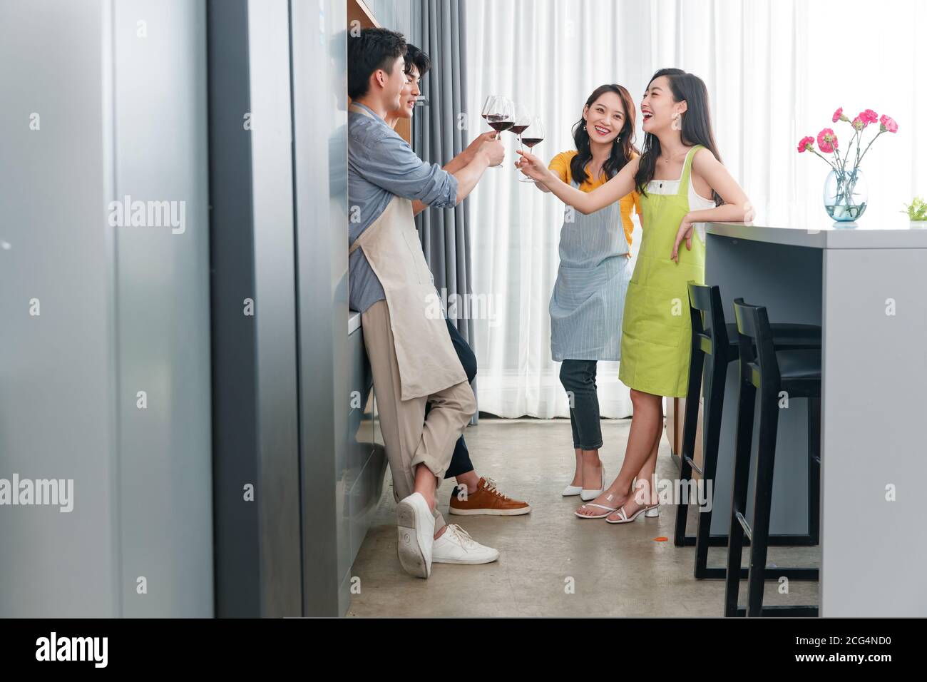Les jeunes amis boivent du vin dans la cuisine Banque D'Images