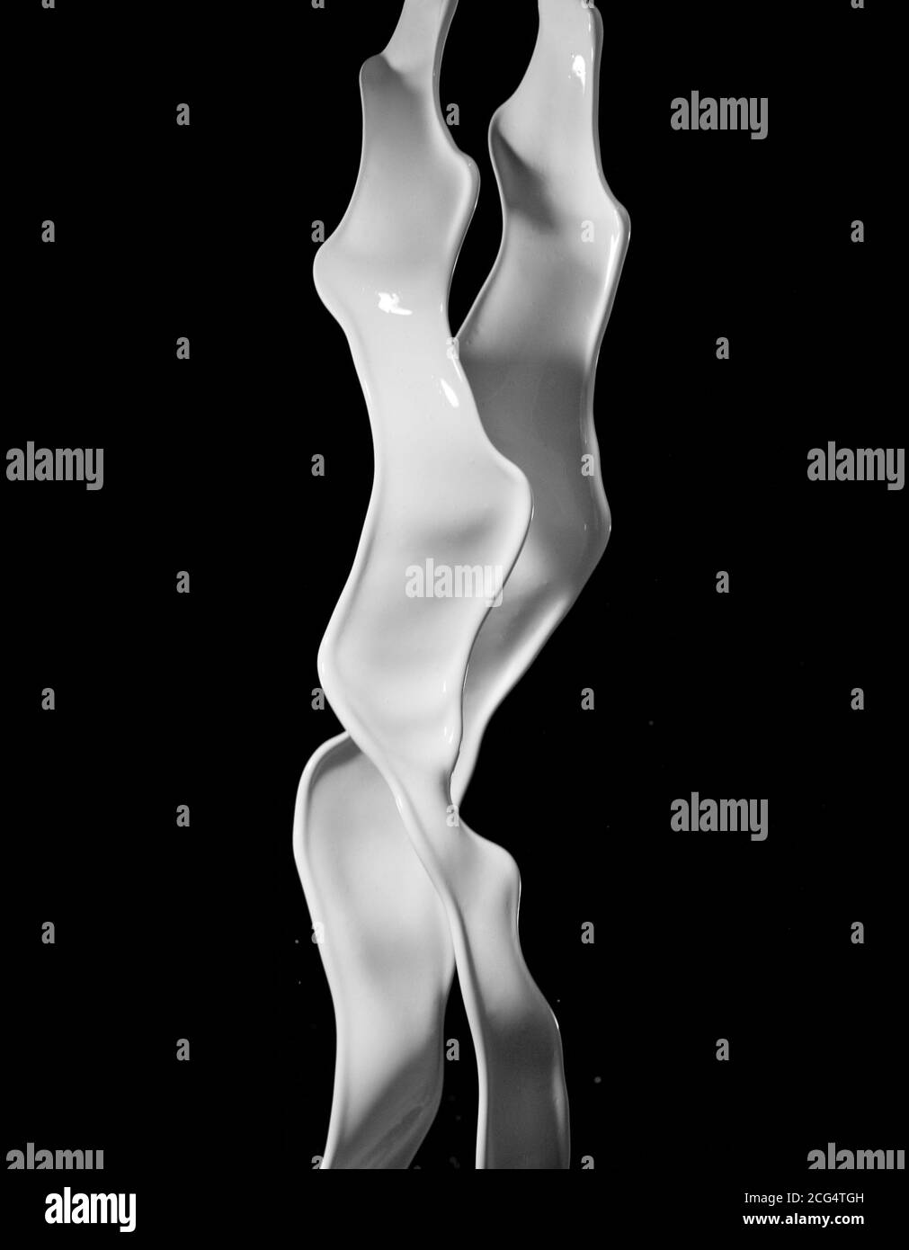 Éclaboussures de lait isolées sur fond noir. Forme abstraite en rotation. Banque D'Images