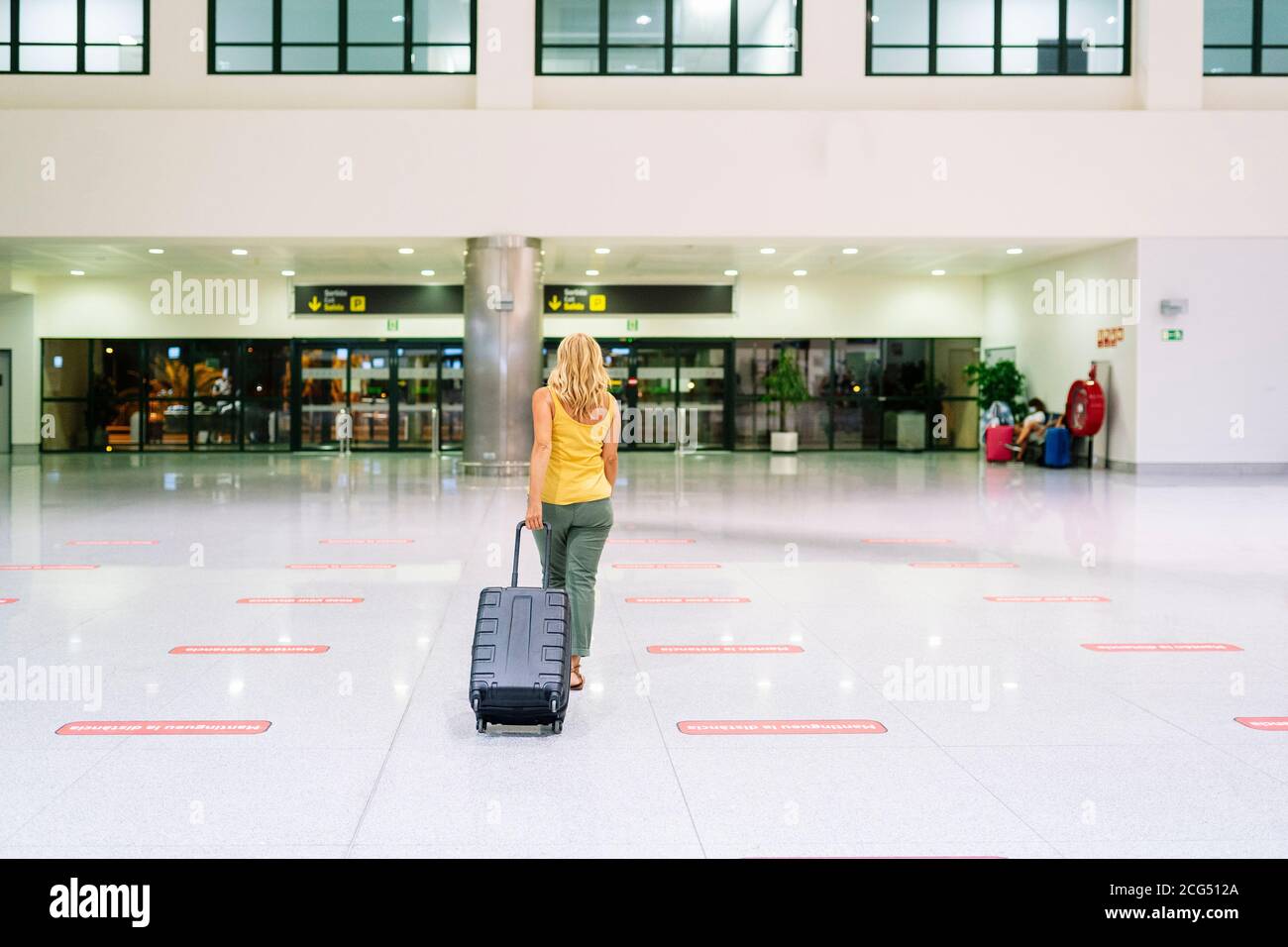 Une femme à l'aéroport avec une valise Banque D'Images