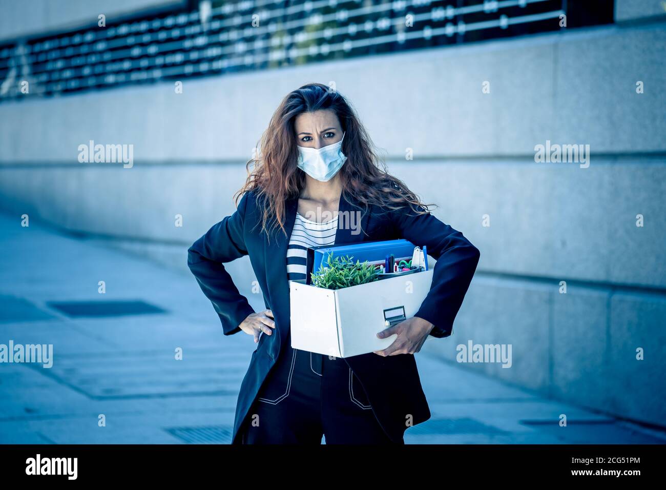 Femme d'affaires déprimée avec masque de visage à l'extérieur du bureau avec boîte personnelle de personnel se sentant désespéré après avoir été tiré du travail. Pertes d'emploi du coronavirus, l Banque D'Images