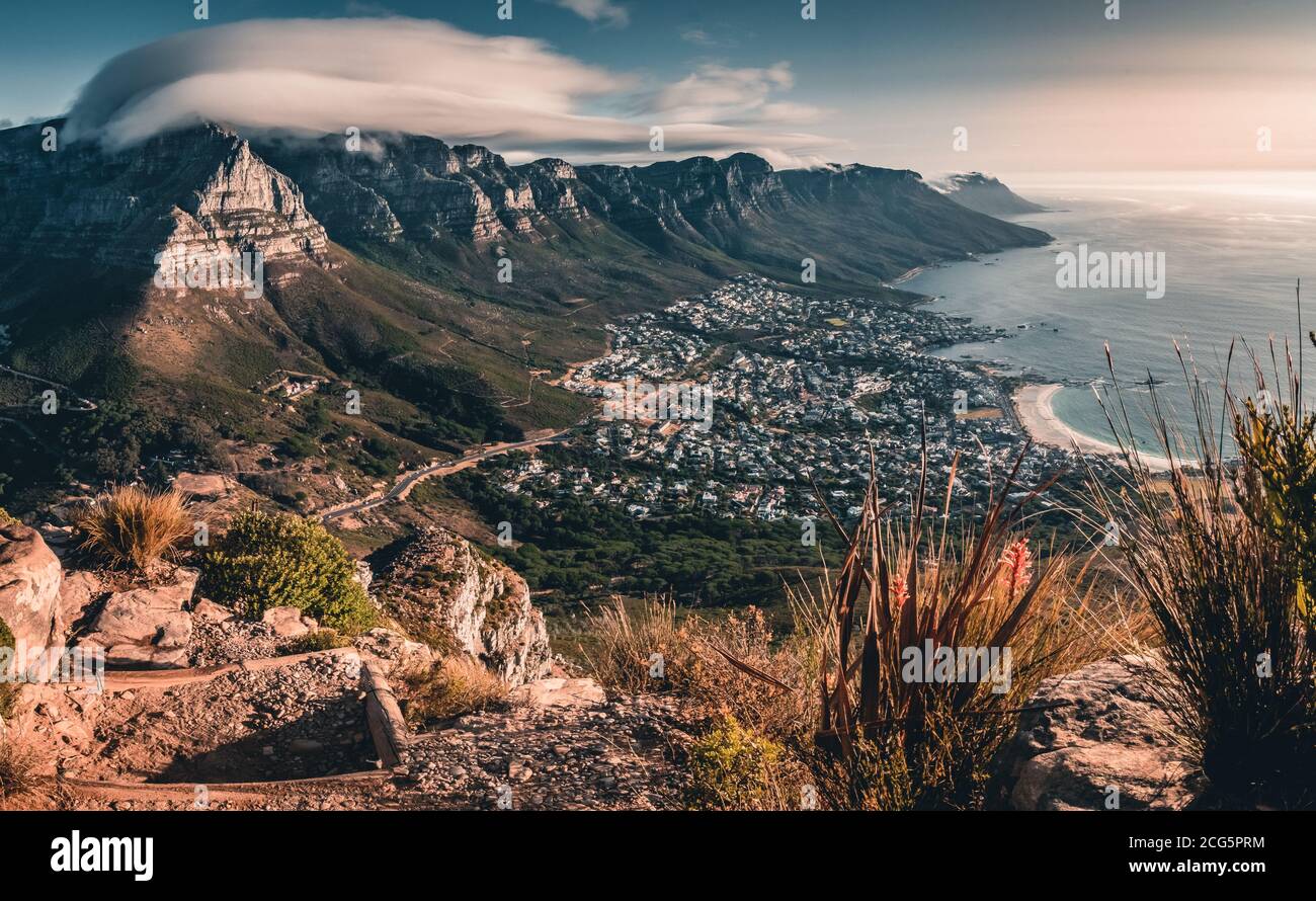 Le nuage coule au-dessus de la montagne de la Table, avec la plage de camps Bay visible pendant la randonnée au coucher du soleil jusqu'à Lion's Head. Banque D'Images