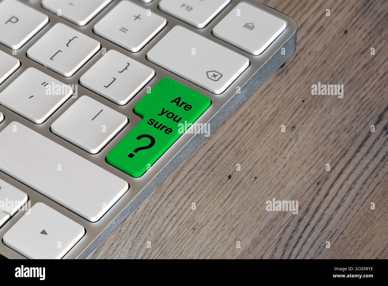 Clavier d'ordinateur avec une question sur le vert lime entrée clé sur un fond de table en chêne Banque D'Images