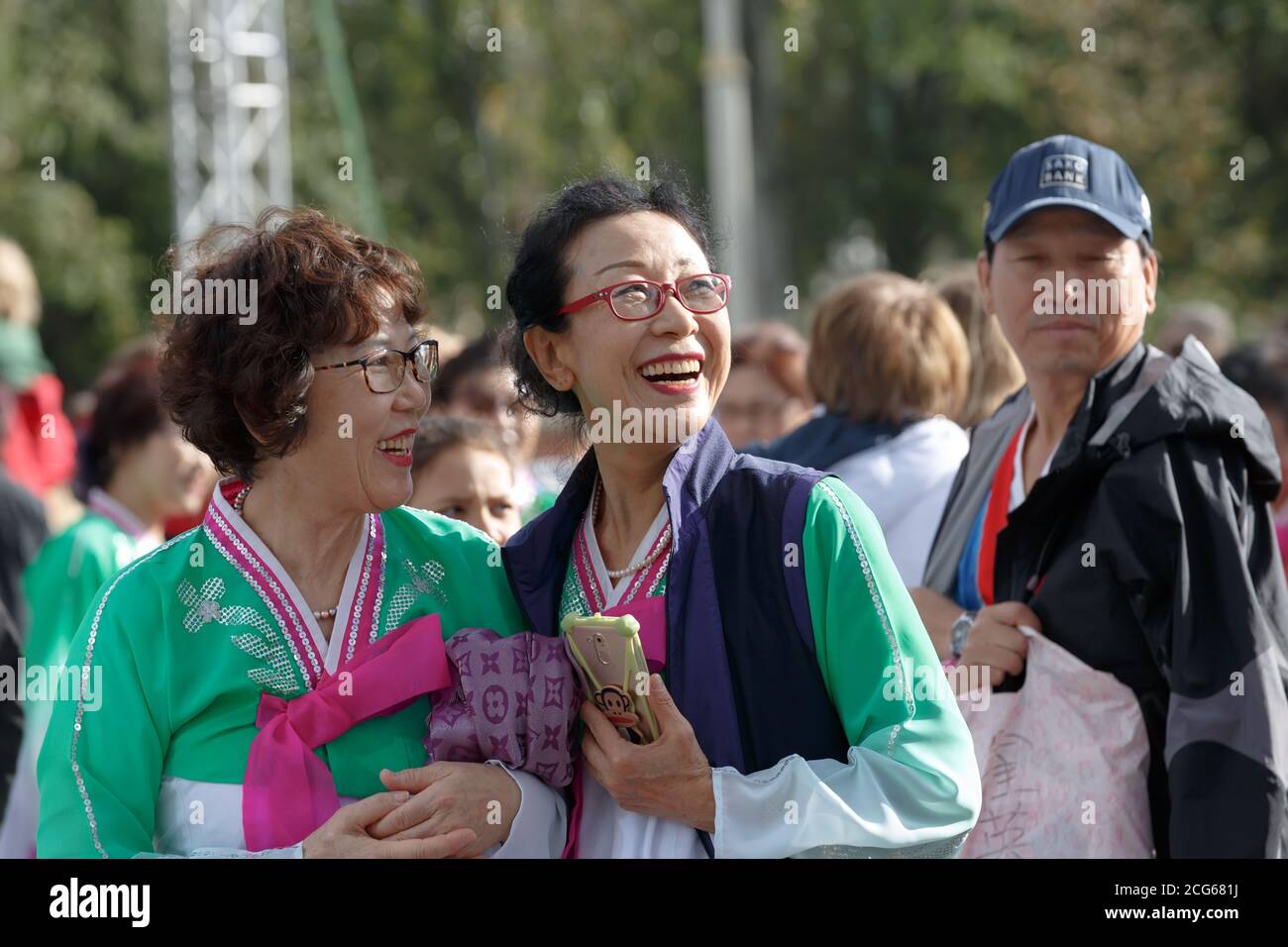 Moscou, Russie, 14 septembre 2019 : deux femmes asiatiques d'âge moyen souriantes portant des lunettes et des costumes brillants au festival chinois de VDNH Banque D'Images