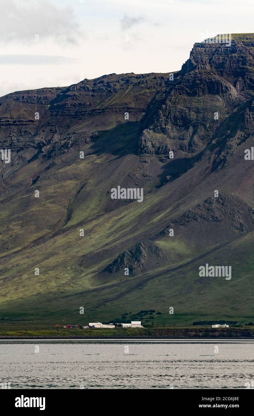 La majestueuse montagne islandaise donne l'impression que le bâtiment est un petit fourmis Banque D'Images