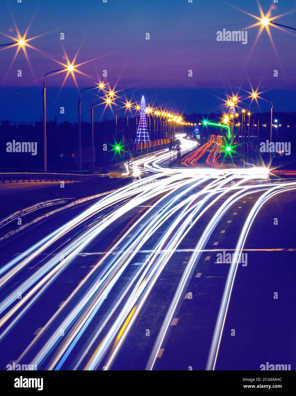 Traces de phares des voitures se déplaçant la nuit sur le pont, illuminés par des lanternes. Paysage urbain abstrait avec autoroute. Banque D'Images