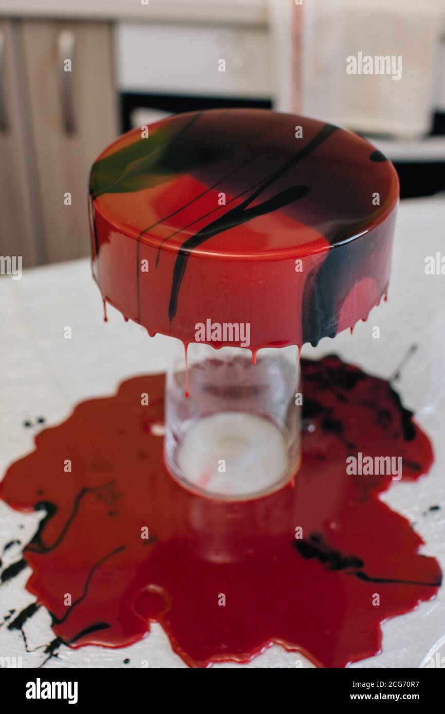 Glaçage séchant sur un chocolat au velours rouge fait maison gâteau Banque D'Images
