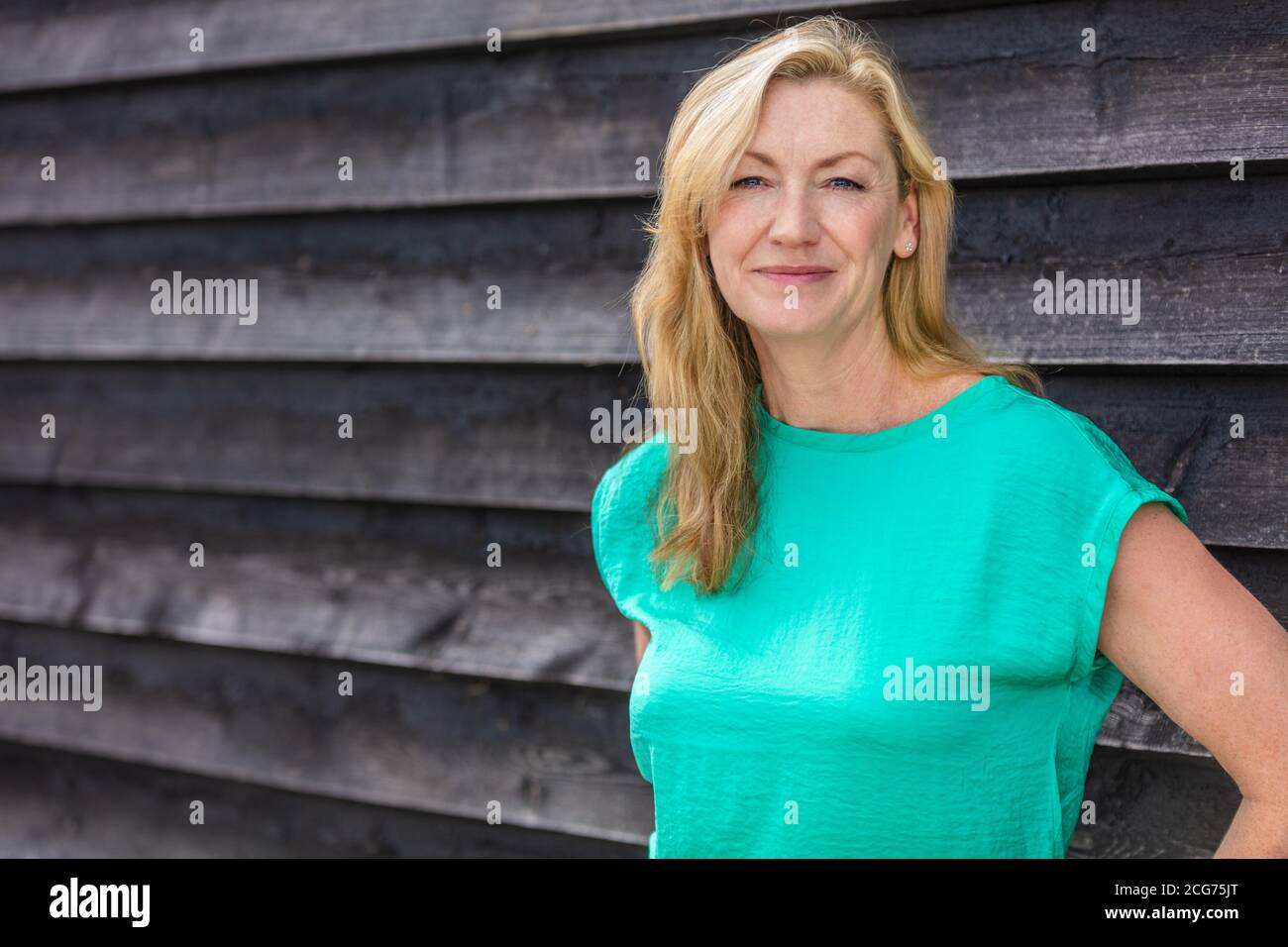 Portrait extérieur d'une jolie femme blonde d'âge moyen souriante Banque D'Images