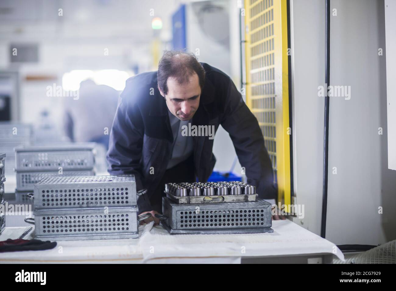 Ingénieur inspectant des pièces de machine dans une usine industrielle, Allemagne Banque D'Images