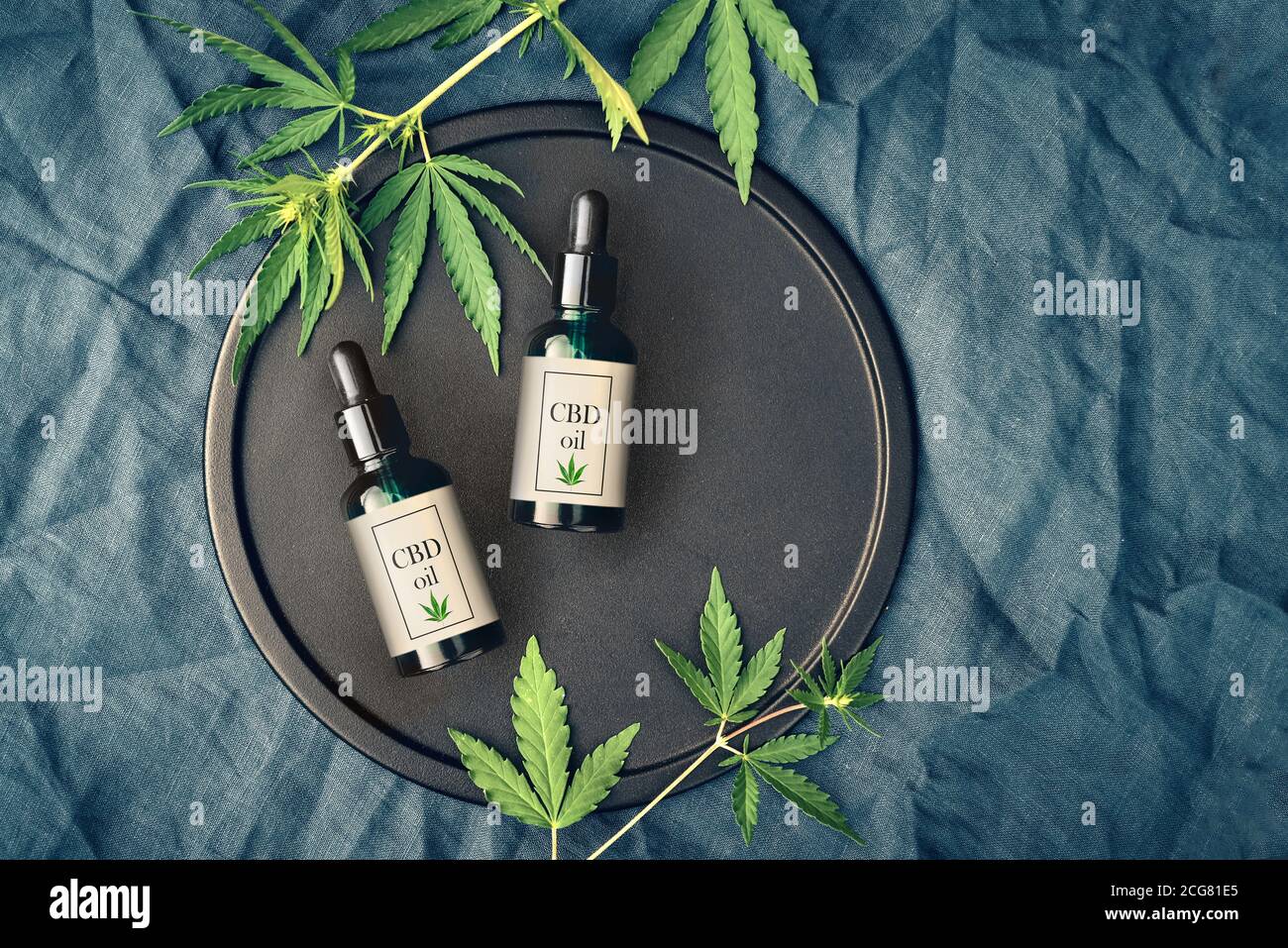 Cannabis produit médical, huile de CBD, avec des feuilles de chanvre sur un plat noir Banque D'Images